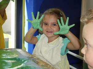 Enfant souriant avec les mains pleine de peinture